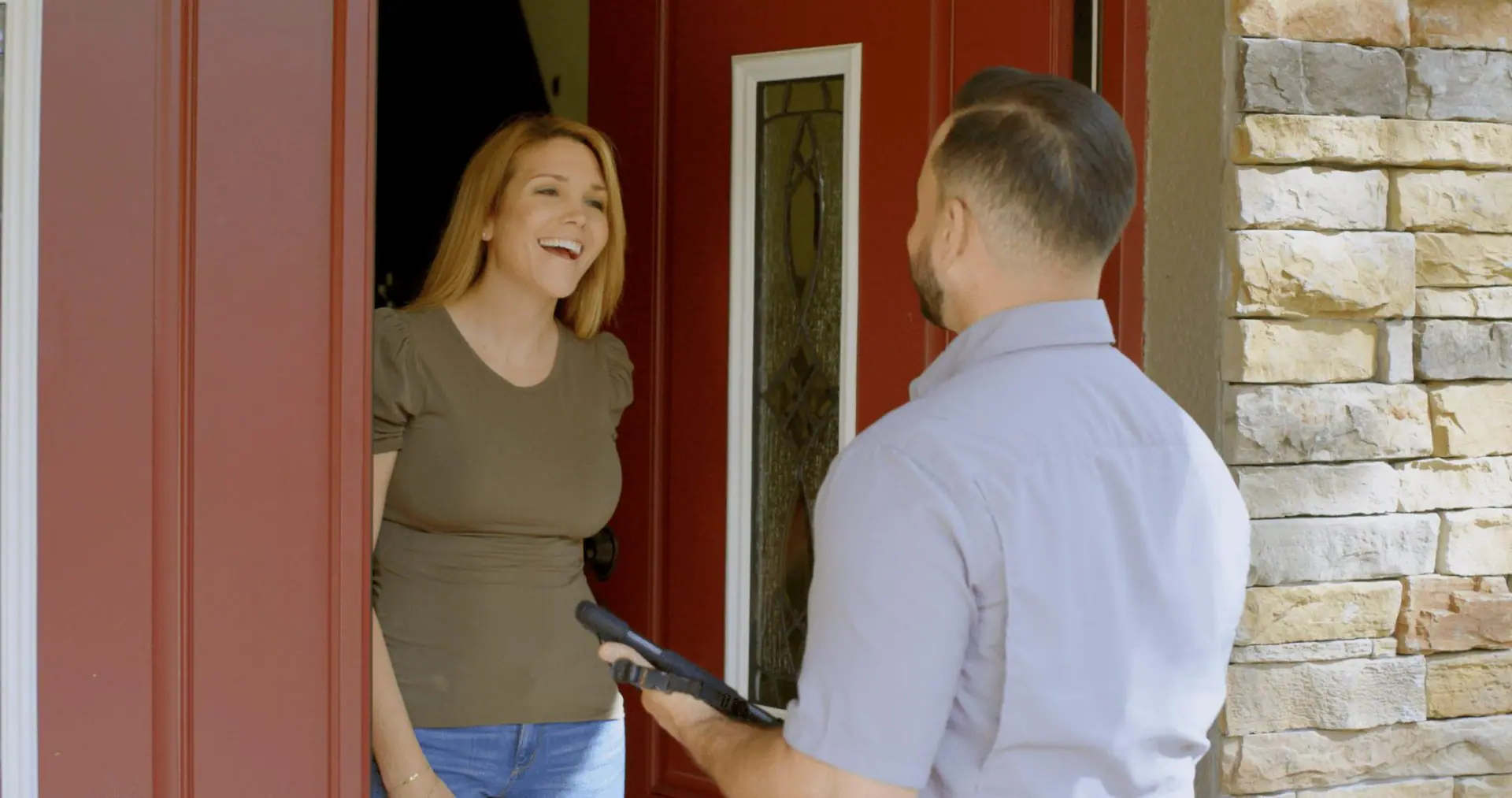 Homeowner talking with Strada Service Technician at front door